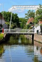 ein Kanal mit ein Brücke Über es und ein Haus auf das andere Seite foto