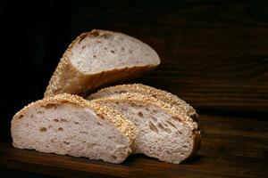 Schnitt Laib von Brot und Stücke von Brot auf ein hölzern Hintergrund. Ciabatta Brot. foto