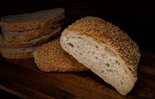 Schnitt Laib von Brot und Stücke von Brot auf ein hölzern Hintergrund. Ciabatta Brot. foto