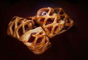 Puff Gebäck Gebäck mit Preiselbeere Marmelade auf ein dunkel rot Hintergrund. Kekse mit Preiselbeere Marmelade. foto