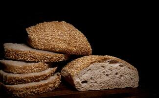 Schnitt Laib von Brot und Stücke von Brot auf ein hölzern Hintergrund. Ciabatta Brot. foto