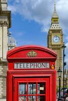 britisch traditionell rot Telefon Stand mit das groß ben im das Hintergrund im London foto