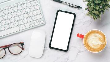 oben Sicht, Weiß Büro Schreibtisch mit Tastatur Computer, leer Bildschirm Clever Telefon, Notizbuch, Brille, Maus und Stift, Kopieren Raum, spotten hoch. foto