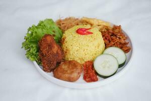 indonesisch Stil Gelb Reis mit Hähnchen und Seite Geschirr im Weiß Teller foto