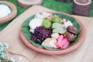 jenang Madura ist ein typisch indonesisch Essen Das besteht von schwarz klebrig Reis, Haferbrei Mark, jenang grendul und rot Perlen Das wurden gegeben Palme Zucker und Kokosnuss Milch foto