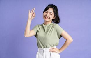 Porträt von schön asiatisch Mädchen posieren auf lila Hintergrund foto