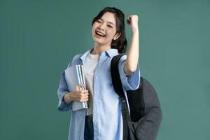 Porträt von ein schön asiatisch Schüler auf ein Grün Hintergrund foto