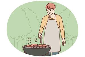 Mann im Schürze Koch Fleisch draußen foto