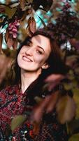 schöne junge Frau in burgunderroten Blättern foto