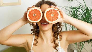 Porträt einer Frau, die ihr Auge mit Grapefruit bedeckt