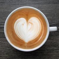 Blick von oben auf eine Tasse Latte-Art-Kaffee.
