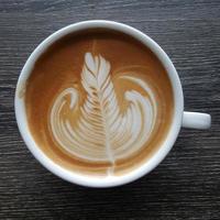Blick von oben auf eine Tasse Latte-Art-Kaffee.