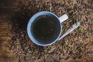 Tasse und Löffel mit Blumentee auf Holzuntergrund foto