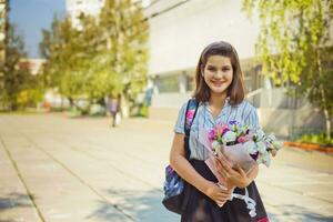 Mädchen mit ein Strauß von Blumen in der Nähe von das Schule. das zuerst von September. das zuerst Lehrer. glücklich Kind. foto