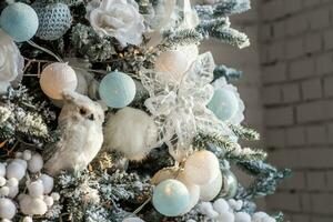 Weihnachten Baum dekoriert mit ein Spielzeug von ein Olive und Girlanden. Weiß und Blau Weihnachten d kor. Neu Jahre Hintergrund. foto