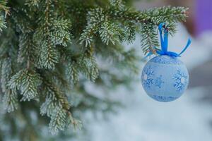 Blau Ball Weihnachten Spielzeug auf das von ein Weihnachten Baum Ast. Weihnachten im das Stadt. Hintergrund zum das Neu Jahr. foto