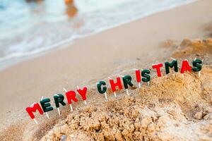 fröhlich Weihnachten zu das Inschrift mit ein Weihnachten Baum. das Anfang von ein Neu Jahr im ein Reise durch das Meer. feiern Weihnachten Vorabend auf Ferien foto