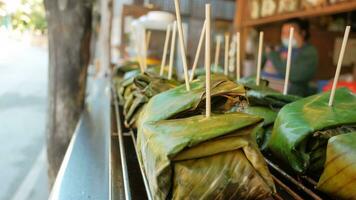 lokal Essen im Nord Thailand gemacht mit gehackt Schweinefleisch und Kokosnuss Milch eingewickelt im Banane Blätter gegrillt auf das Herd. foto