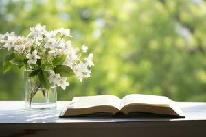 Jasmin Blumen im ein Vase und öffnen Buch auf das Tisch, Grün natürlich Hintergrund. ai generiert foto