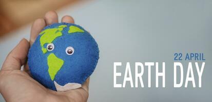 Text Erde Tag. Erde im Frau Hand. hausgemacht Spielzeug gemacht von fühlte mit Ozeane und Land. speichern das Planet. Welt Ozean Tag, Speichern Wasser Kampagne. foto