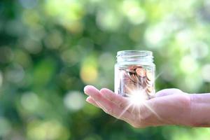 Geld sparen Konzept, Hand mit Münze im Glas foto