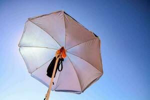 ein Weiß Regenschirm mit ein schwarz Gurt foto