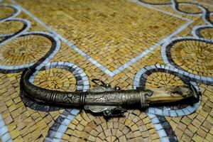 ein Messer Verlegung auf ein Mosaik Fußboden foto