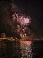 bunt Feuerwerk im das Nacht Himmel auf das direkt am Meer von alicante Spanien foto