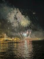 bunt Feuerwerk im das Nacht Himmel auf das direkt am Meer von alicante Spanien foto