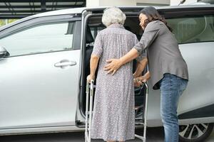 asiatisch Senior Frau geduldig Sitzung auf Gehhilfe bereiten erhalten zu ihr Auto, gesund stark medizinisch Konzept. foto