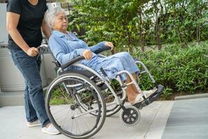 Pflegekraft Hilfe und Pflege asiatisch Senior Frau geduldig Sitzung auf Rollstuhl zu Rampe im Pflege- Krankenhaus, gesund stark medizinisch Konzept. foto