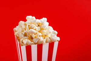 Glas mit Popcorn auf ein rot Hintergrund foto