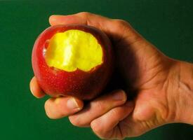 ein Hand halten ein Apfel mit ein beißen genommen aus foto