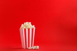 Glas mit Popcorn auf ein rot Hintergrund foto