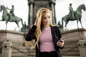 junge Frau mit Handy auf der Straße von Wien, Österreich