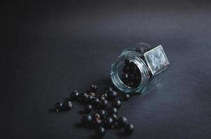 Glas mit Johannisbeeren auf schwarzem Hintergrund. foto