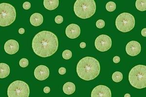 Zitronen- und Limettenscheibe und frische Zitrusfrüchte auf grünem Hintergrund. foto