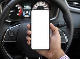Hand, die beim Autofahren einen leeren Bildschirm des Smartphones hält. foto