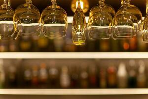 sauber Wein Brille hängend Über das Bar Zähler auf aus von Fokus Hintergrund foto