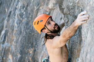 Felsen Klettern mit draussen Sicherheit Geschirr und Helm. foto