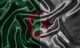 Tapete von Algerienflagge und wehende Flagge von Stoff. foto