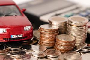 Auto auf Münzen. Autokredit, Finanzierung, Geld sparen, Versicherung, Leasing