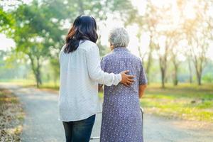 Hilfe und Pflege asiatische Seniorin verwendet Walker im Park. foto