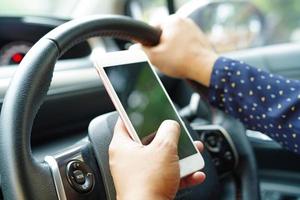 Handy im Auto zur Kommunikation halten foto
