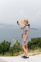 Frau fotografiert das Stadtbild mit dem Handy foto