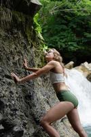 junge glückliche Frau genießt den Wasserfall foto