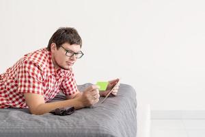 junger Mann mit Tablet im Internet einkaufen