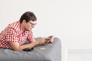 junger Mann mit Tablet im Internet einkaufen