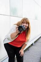 Porträt einer übergewichtigen Frau, die im Freien Bilder mit einer Kamera macht