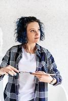 Kreative Frau mit blau gefärbten Haaren malt in ihrem Atelier